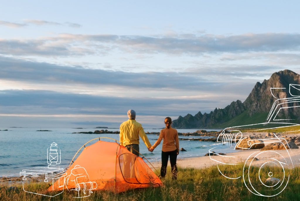 couple holding hands by tent on the beach