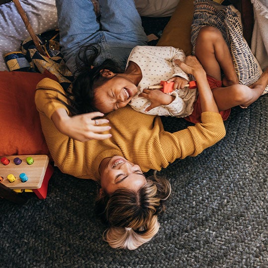 Parent and Child laying on the floor laughing