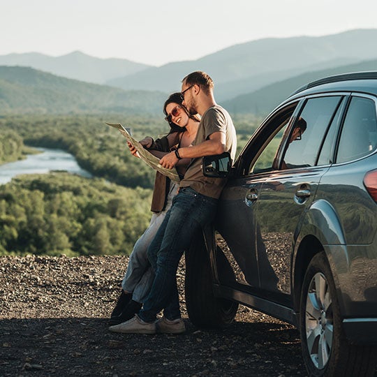 Couple leaning on a car